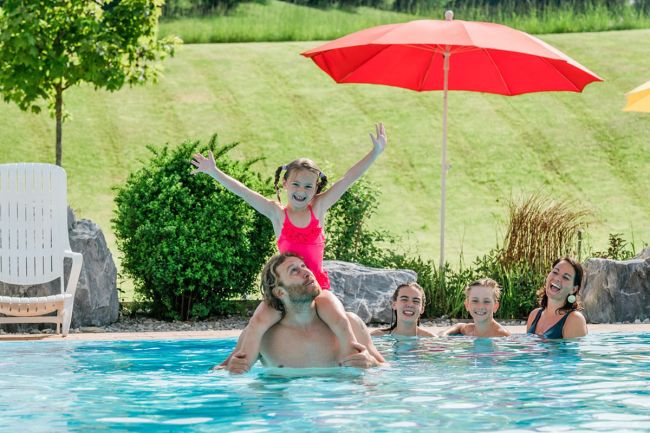 Familie schwimmt im Freibad in der Therme Amadé